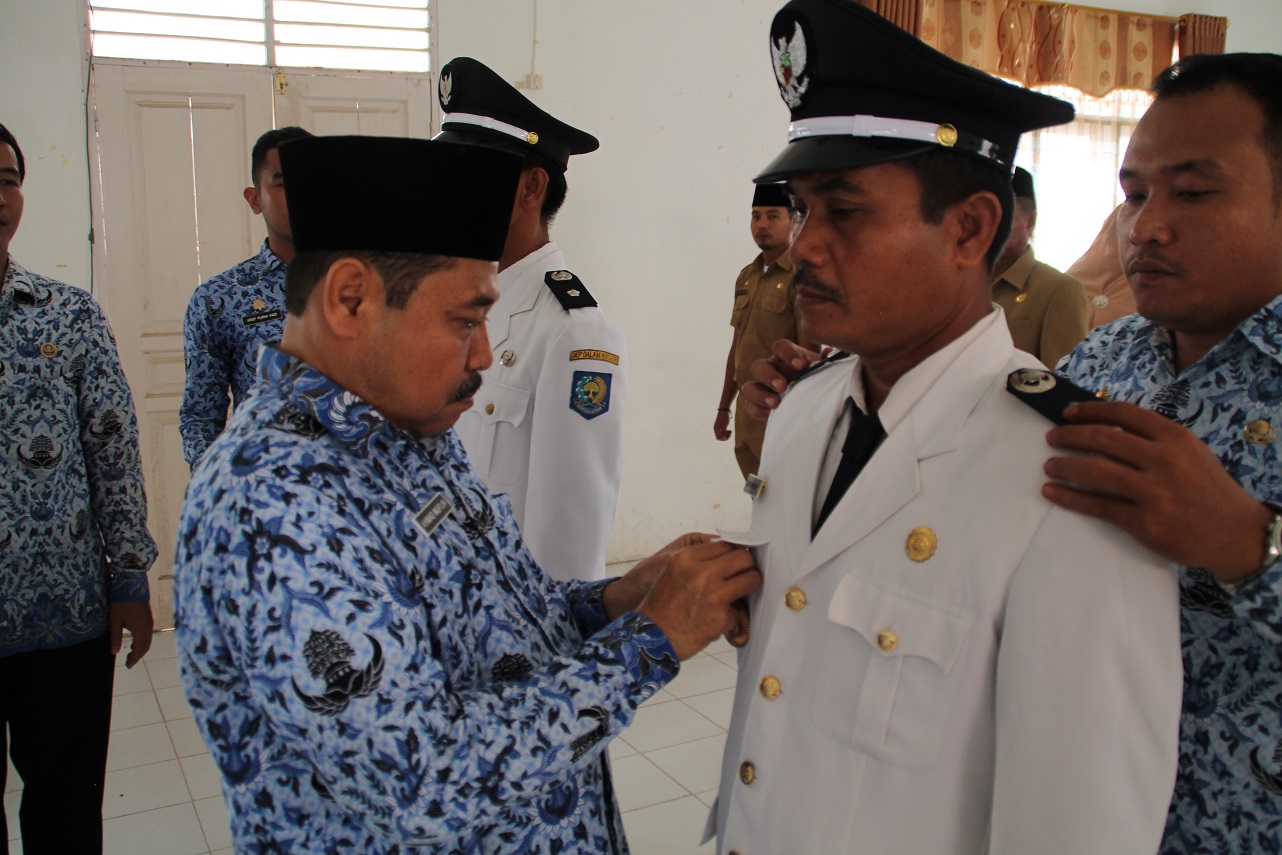 IMG  Teks Foto : Plt. Sekdakab Labuhanbatu Ahmad Muflih, SH, MM sedang menyematkan tanda jabatan Lurah Sioldengan kepada Edi Martin Harahap, S.Pd.