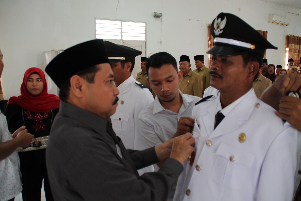 Teks Foto : Plt. Sekdakab Labuhanbatu Ahmad Muflih, SH, MM saat menyematkan tanda jabatan kepada M Awal Hasibuan Kepala Kelurahan Ujung Bandar Kecamatan Rantau Selatan.